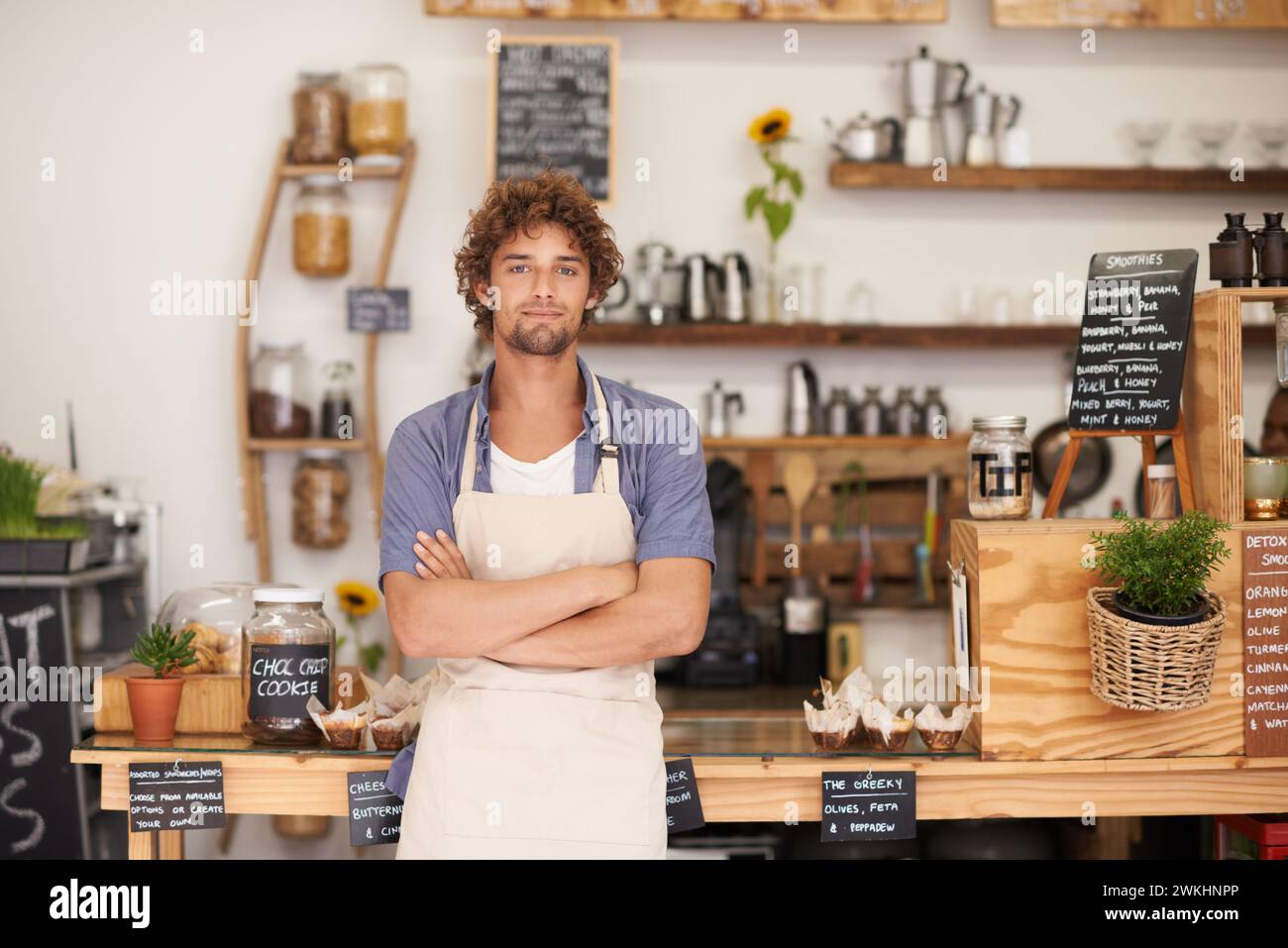 Ritratto, benvenuto e uomo con fiducia nel ristorante per il servizio con il felice proprietario di una piccola impresa. Caffetteria locale, caffetteria o direttore di bistrot con Foto Stock