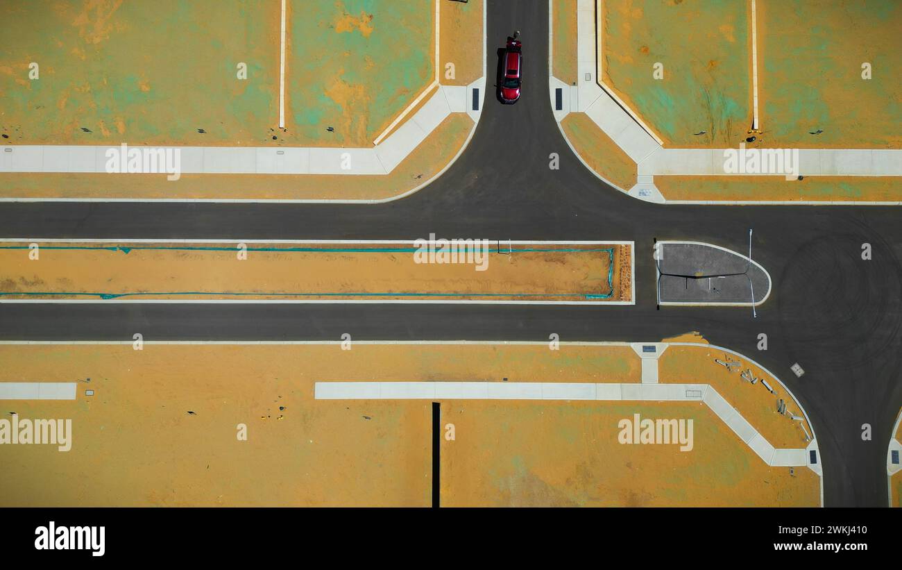 Vista aerea di un cantiere che mostra nuove strade e terreni con un'auto parcheggiata sulla strada per dare un'impressione di scala. Foto Stock