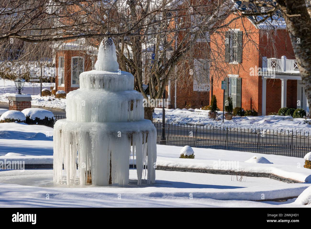 Abingdon, Virginia, USA - 21 gennaio 2024: Una fontana d'acqua ghiacciata circondata dalla neve nel cortile anteriore del Martha Washington Hotel in centro Foto Stock