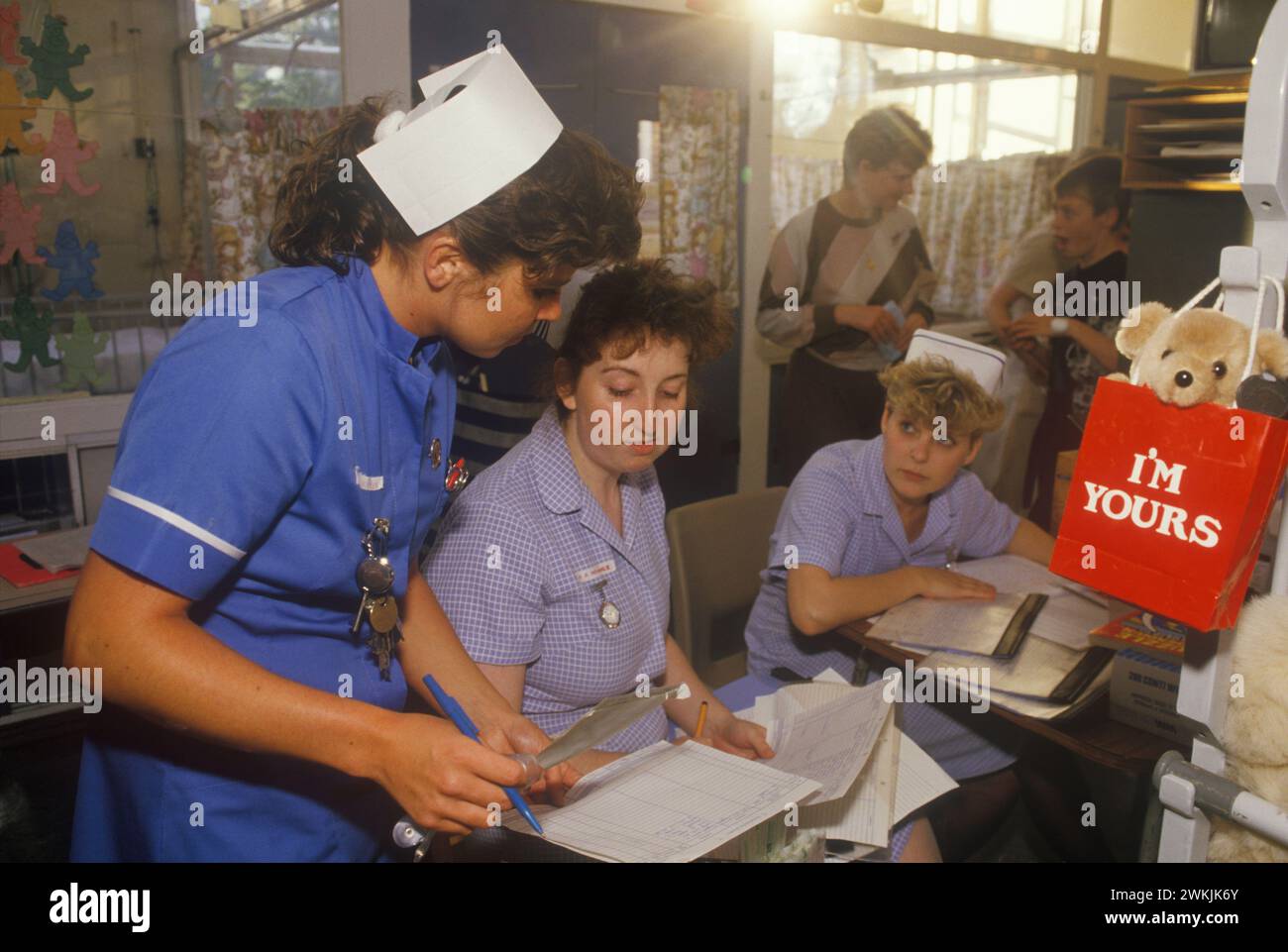 Infermiera dello staff Catherine Ellis all'ospedale pediatrico Alder Hey, con due infermieri, che confrontano e controllano i dati ospedalieri dei pazienti. Liverpool, Inghilterra anni '1988 1980 Regno Unito HOMER SYKES Foto Stock