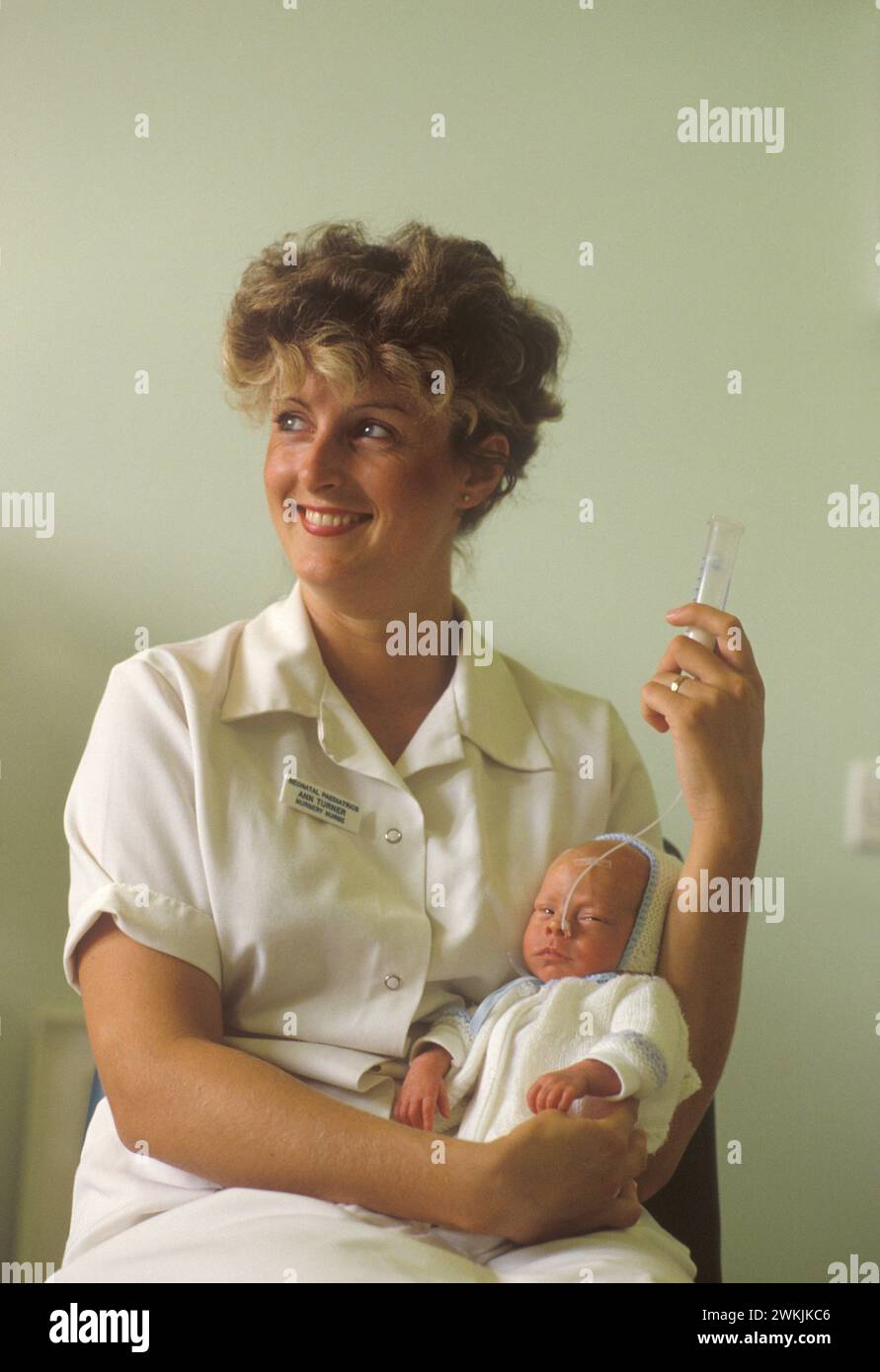 NHS 1980S.. Premature Baby Unit presso il Nottingham General Hospital, infermiera pediatrica neonatale Ann Turner che allatta un bambino con un tubo di alimentazione. Nottingham, Nottinghamshire, Inghilterra intorno agli anni '1980 HOMER SYKES Foto Stock