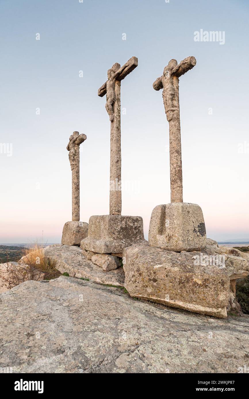 Tre croci di pietra scolpita su roccia di granito al crepuscolo del cielo Foto Stock