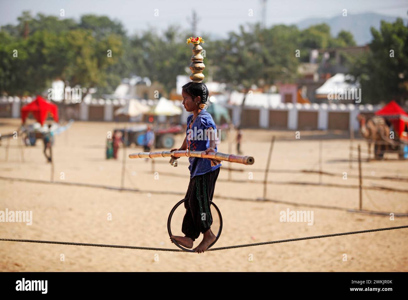 Un giovane equilibrio alla Pushkar Camel Fair, Rajasthan, India. Foto Stock