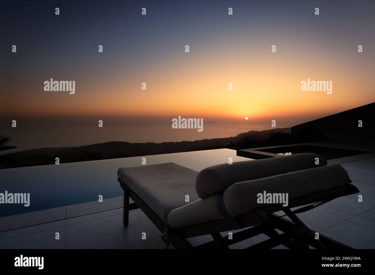 Serenità al crepuscolo: Tramonto sulla piscina con vista oceano Foto Stock