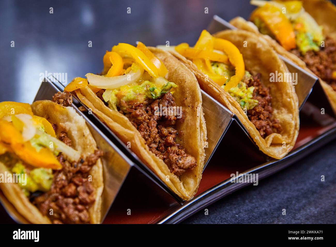 Tacos di manzo con guacamole e peperoni in supporto metallico Foto Stock