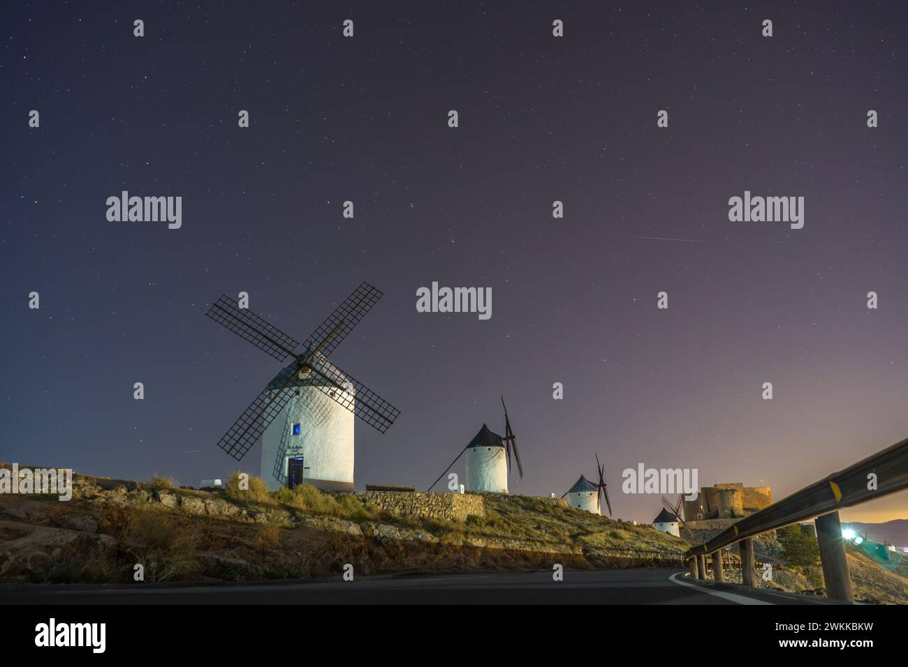 Cielo stellato sotto i mulini a vento della città medievale di Consuegra. Mulini a vento nelle terre di Don Chisciotte e Sancho Panza. Castilla la Mancha. Foto Stock