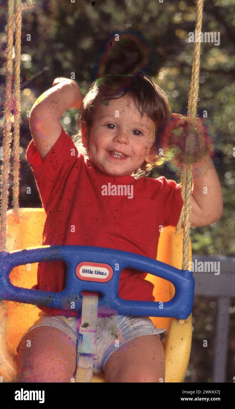 Il diciannovenne Anglo boy ama la sensazione di movimento mentre gioca in un'altalena di plastica. ©Bob Daemmrich simile su Alamy Foto Stock