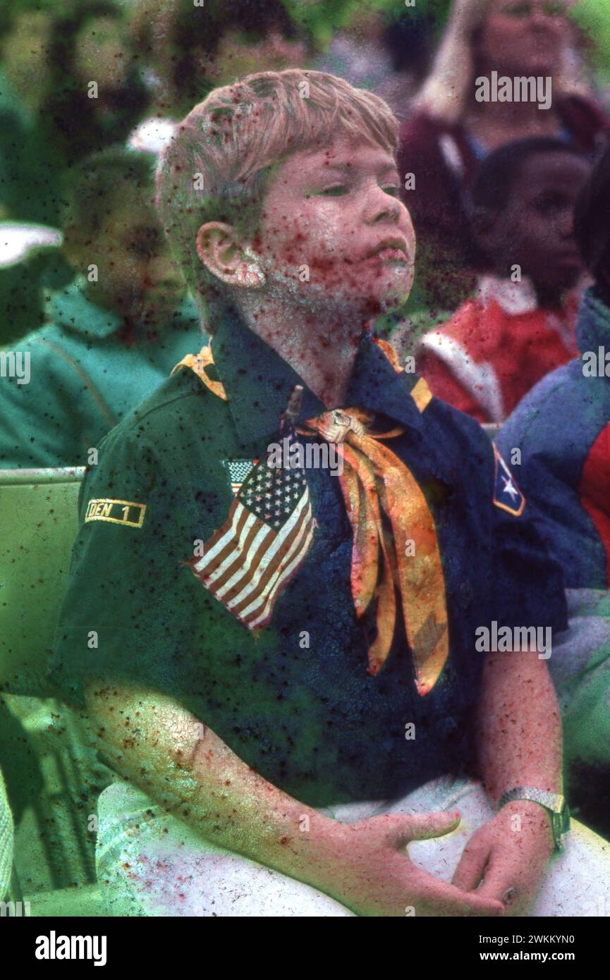 Un ragazzo di quarta elementare che indossa la camicia e la sciarpa Cub Scout ascolta durante un programma del Veterans Day nella sua scuola. ©Bob Daemmrich Foto Stock