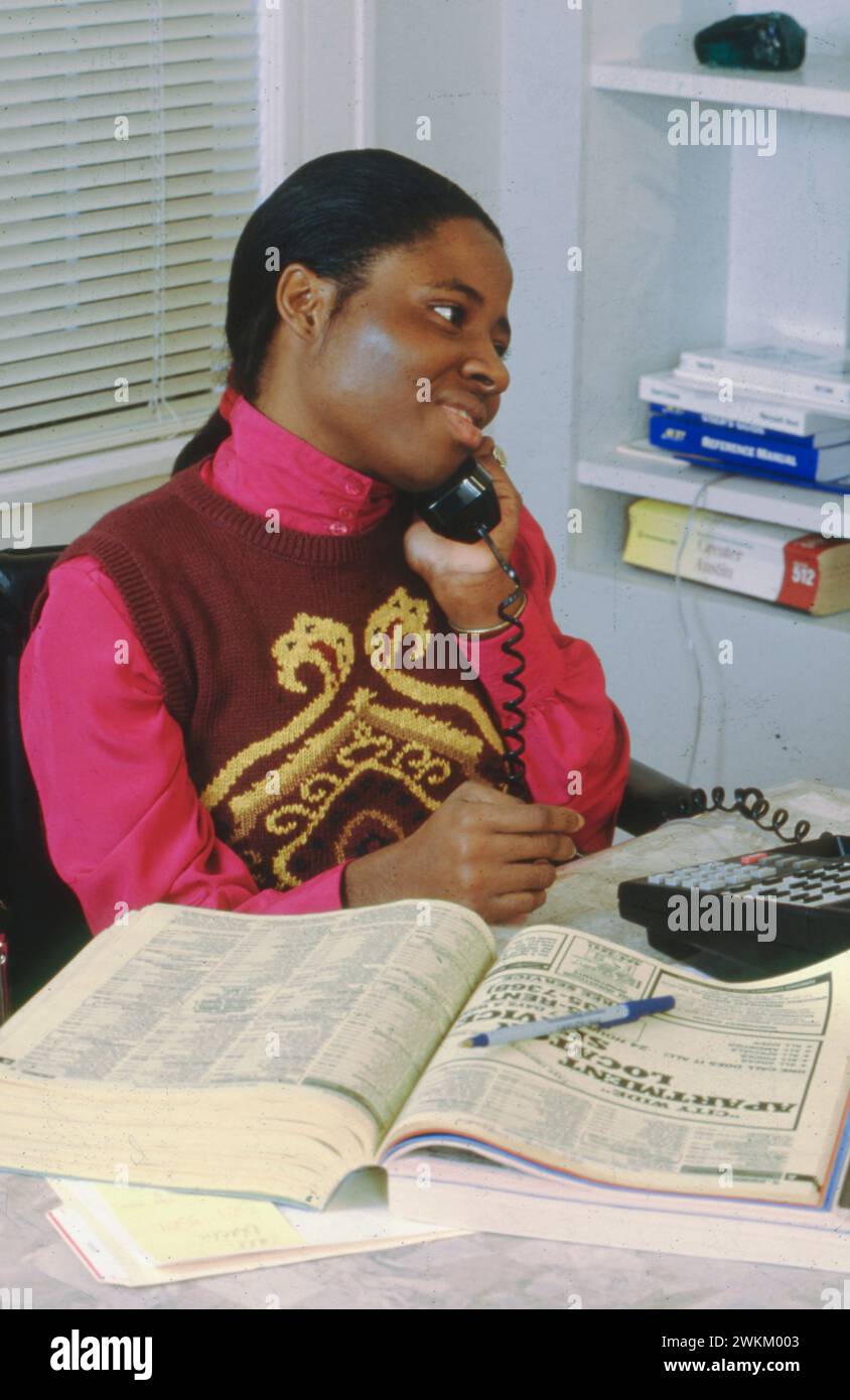 Austin Texas USA, 1993La donna africana disabile con paralisi cerebrale parla al telefono al suo lavoro. ©Bob Daemmrich Foto Stock