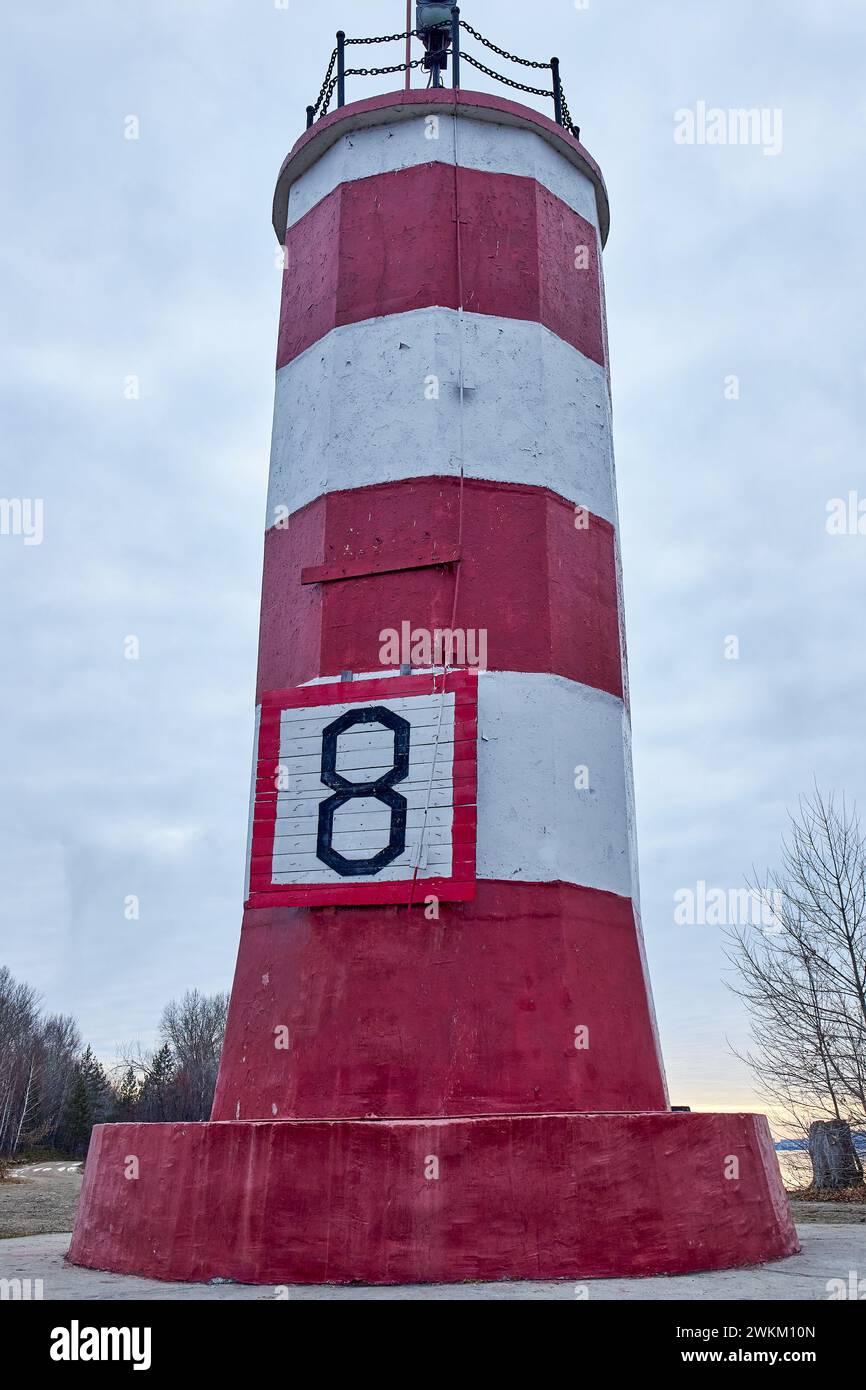 Piccolo faro dipinto con strisce rosse e bianche con il numero 8. Edificio a Novosibirsk, città russa, Siberia, OB Sea, fiume. Destina dei turisti Foto Stock
