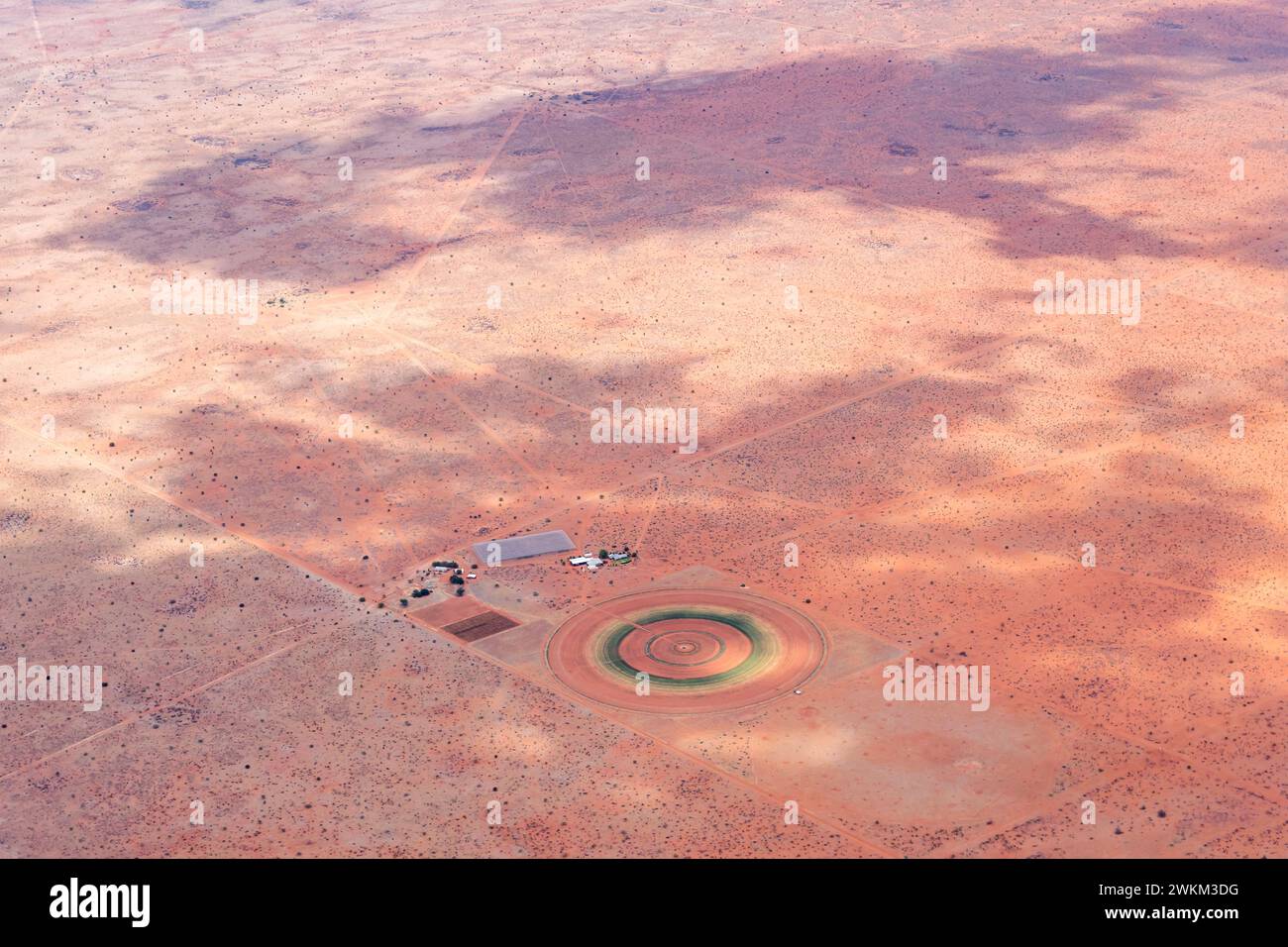 Paesaggio aereo con una piccola fattoria e un campo colorato circolare nel deserto del Kalahari, scattato da un aereo aliante con la luce brillante della tarda primavera a est di Ulenh Foto Stock