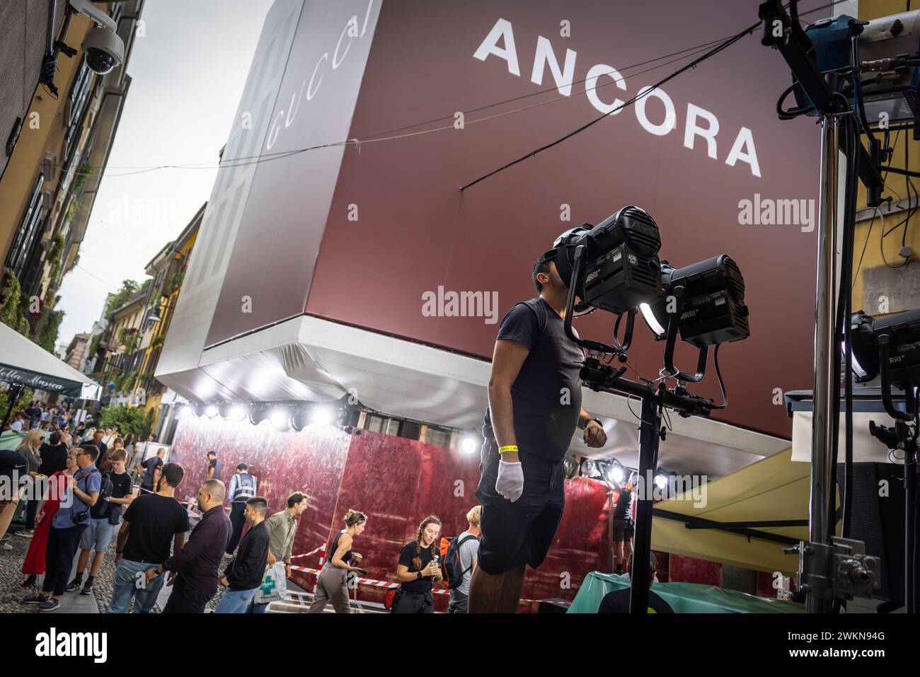 I lavoratori preparano e testano le luci e creano piste lungo una stradina di Milano in preparazione alla settimana della moda autunnale. Foto Stock