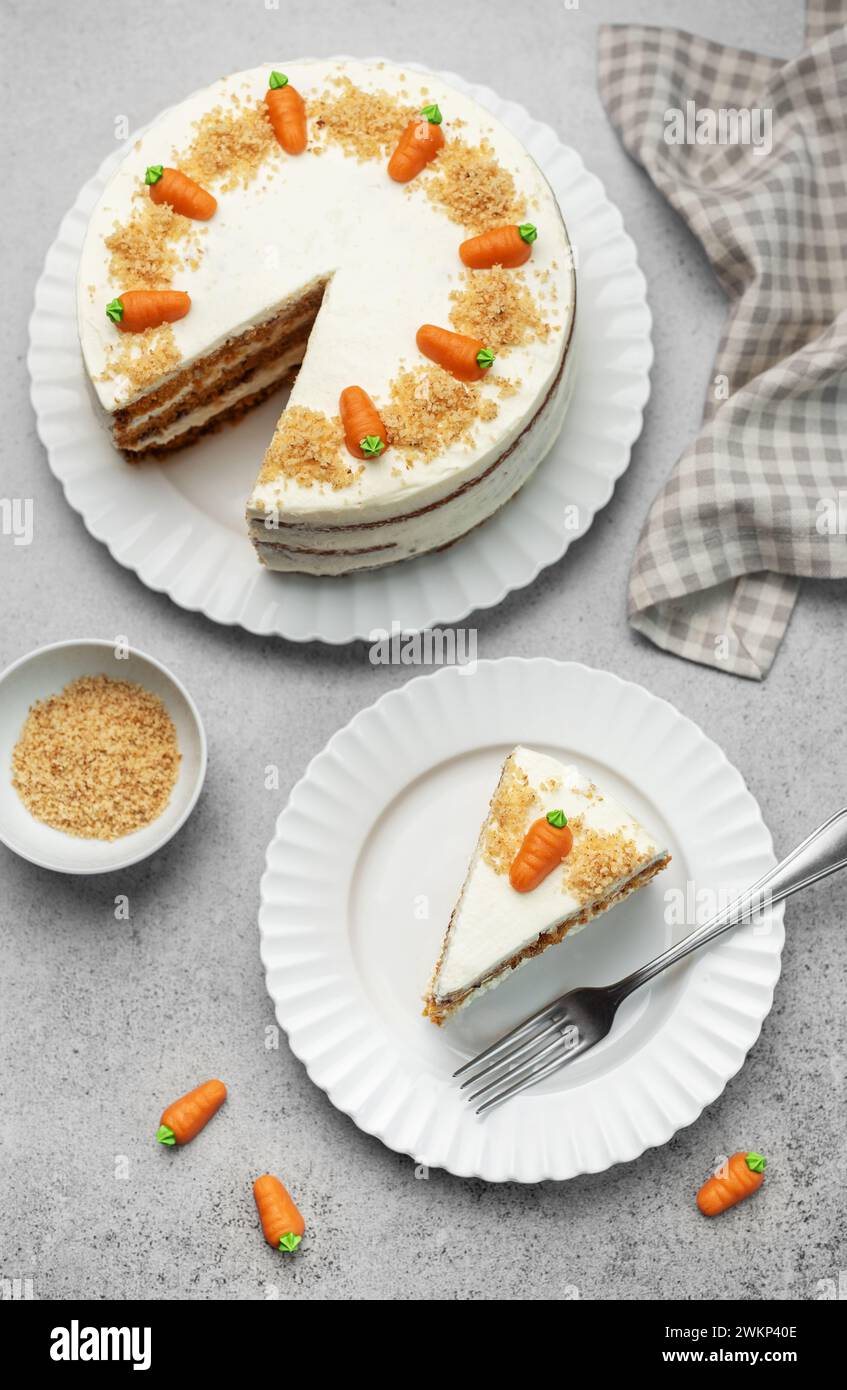 Torta di carote fatta in casa con noci, ghiacciata con formaggio spalmabile. Dolce dolce. Piatto con deliziosa torta di carote Foto Stock