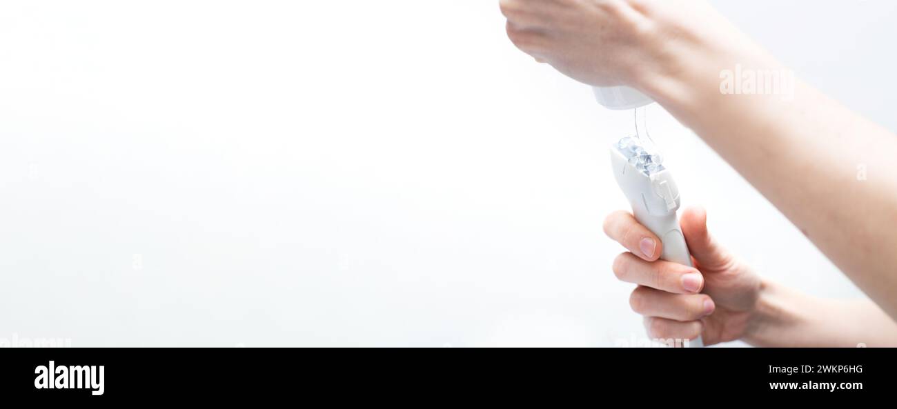 La mano del medico della donna applica un gel medico al sensore ultrasonico della macchina ultrasonica nella clinica isolato su sfondo bianco. Ecografia scanni Foto Stock