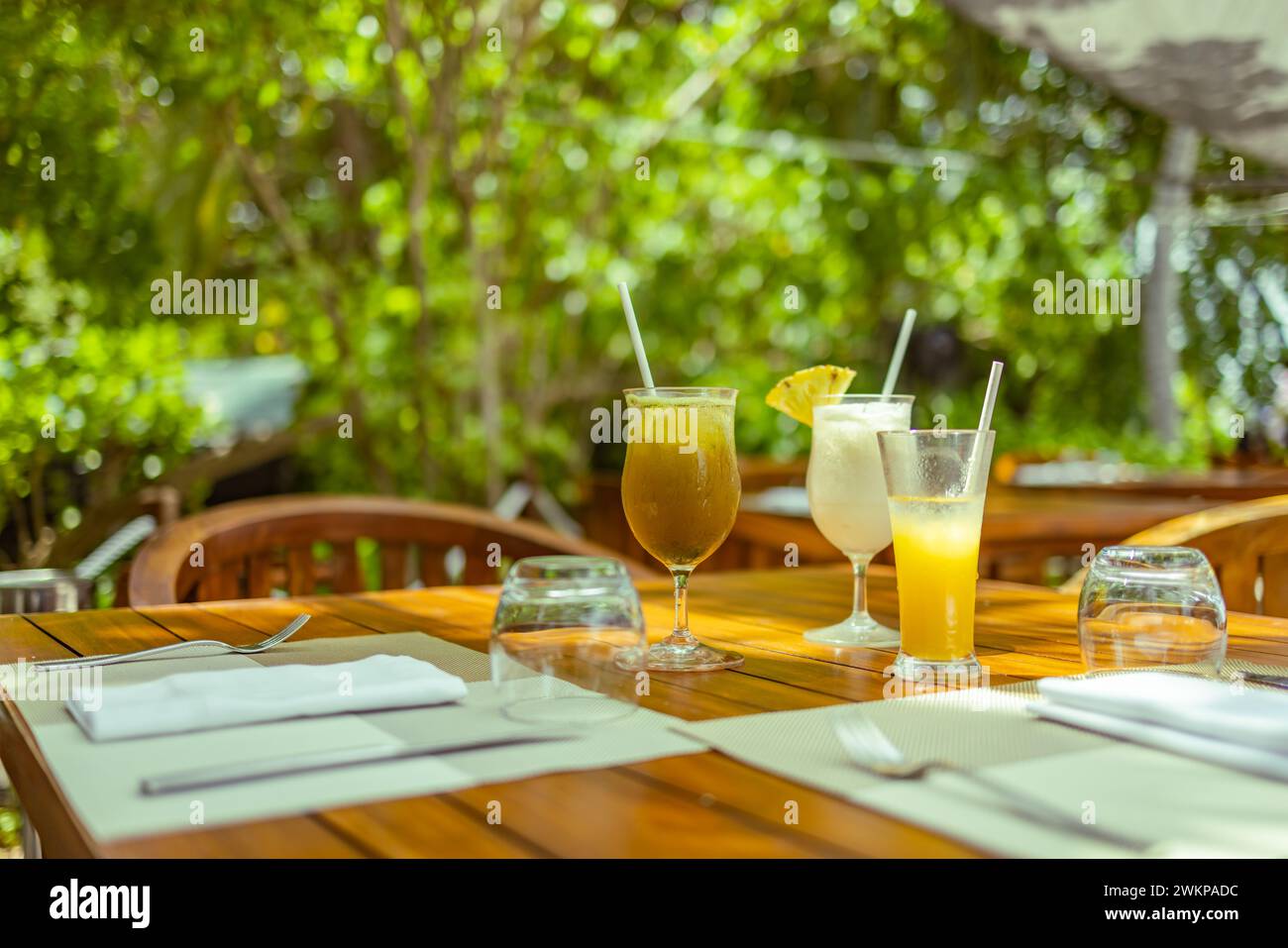 Hotel resort di lusso, ristorante all'aperto sotto le palme e il cielo, caffetteria tropicale dell'isola, tavoli, cibo, cocktail. Vacanze estive o vacanze Foto Stock