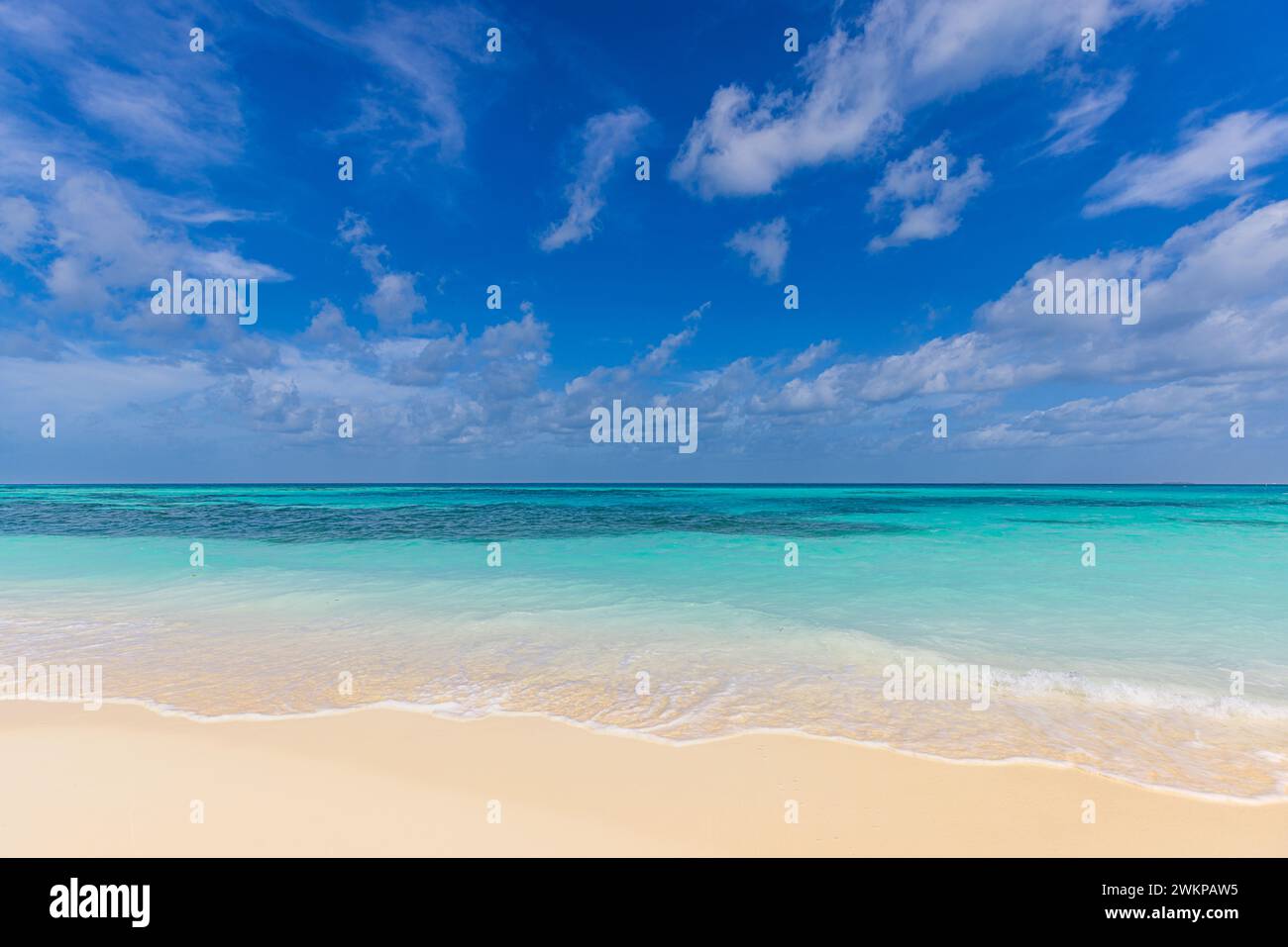 Spiaggia astratta sullo sfondo del mare. Sabbia bianca soleggiata, cielo blu e calmo paesaggio tropicale. Concetto di costa costiera con natura esotica Foto Stock