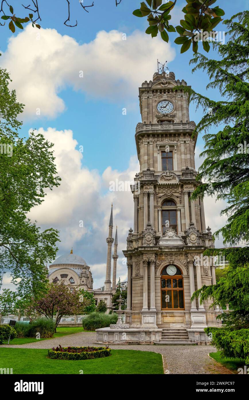 Foto mattutina della Torre dell'Orologio di Dolmabahce, o Dolmabahce Saat Kulesi, situata all'esterno del Palazzo Dolmabahce, Istanbul, Turchia, con sullo sfondo la Moschea Dolmabahce in stile barocco Foto Stock