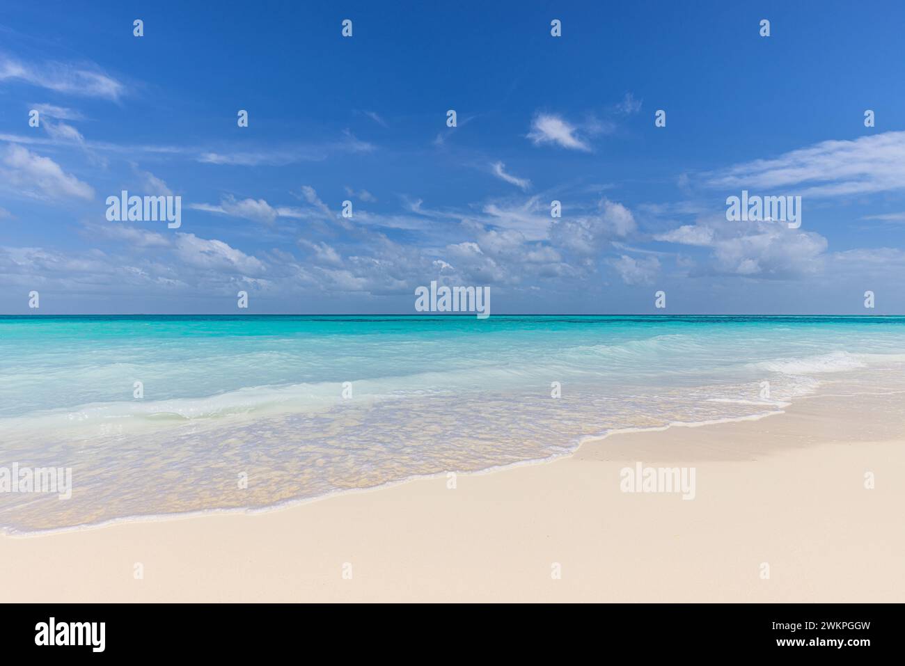 Spiaggia tranquilla e perfetta, luce soffusa del sole e sabbia bianca e mare blu senza fine come paesaggio tropicale. cielo felice dell'oceano azzurro e soleggiato. Costa idilliaca Foto Stock
