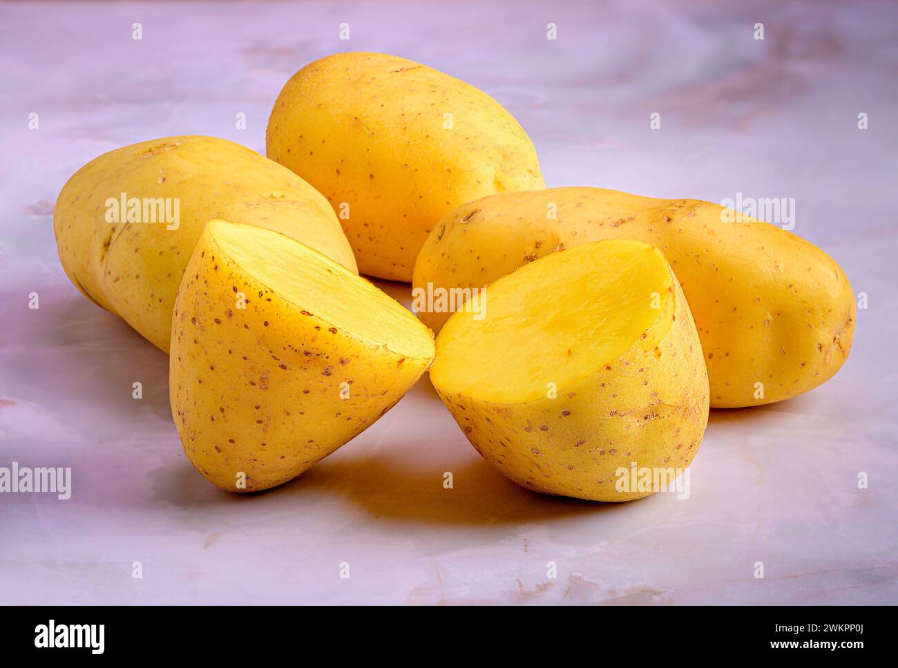 Le patate tagliate in quattro sono disposte ordinatamente su un piatto. Foto Stock