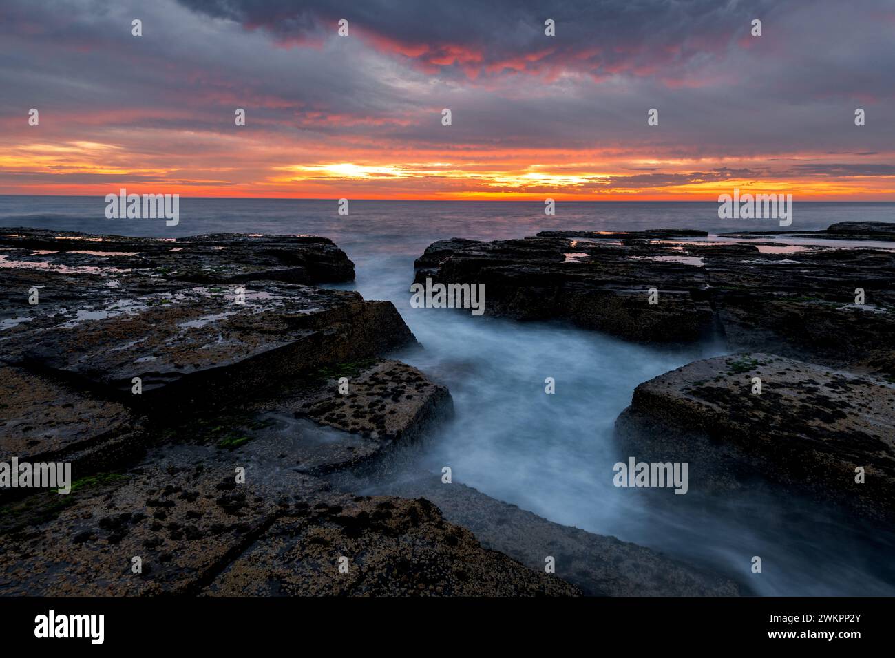 Alba sulle rocce di Narrabeen, sulle spiagge settentrionali di Sydney. Foto Stock