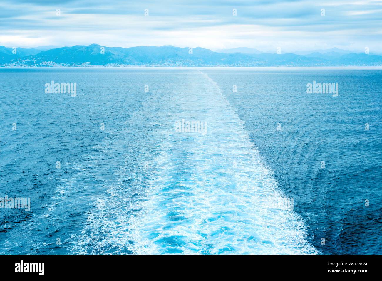 Traccia nave dritta in mare contro la costa lontana Foto Stock