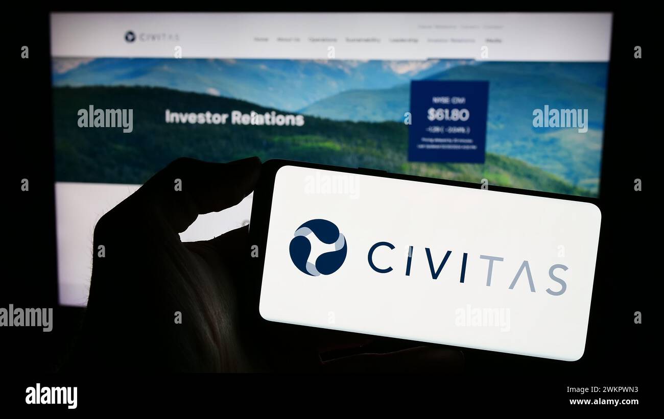 Persona che possiede uno smartphone con il logo della società petrolifera statunitense Civitas Resources Inc. Davanti al sito Web. Mettere a fuoco il display del telefono. Foto Stock