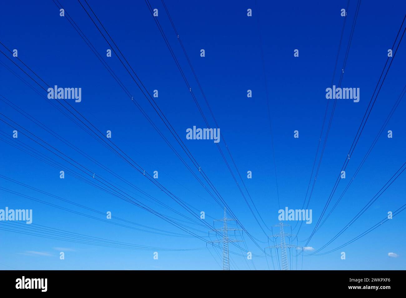 Linee ad alta tensione con piloni contro un cielo blu Foto Stock