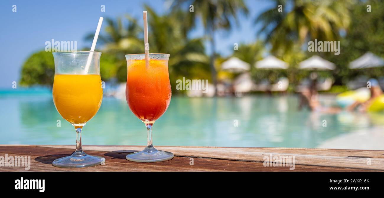 Cocktail colorati serviti in un lussuoso resort tropicale alle Maldive. A bordo piscina con palme e lettini sfocati e luce solare. Giornata di sole Foto Stock