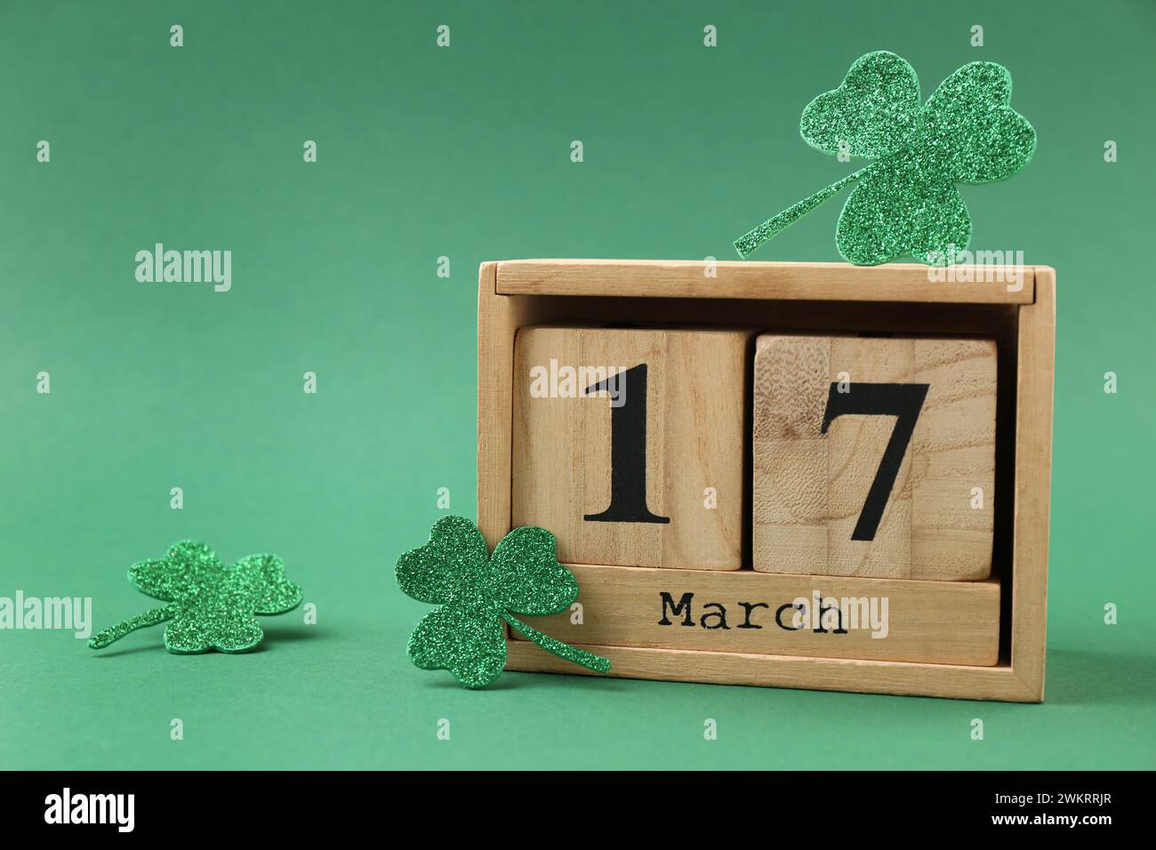 St Giorno di Patrick - 17 marzo. Calendario a blocchi e quadrifoglio decorativo su sfondo verde. Spazio per il testo Foto Stock
