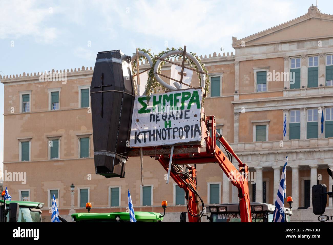 Firmi in greco dicendo "oggi l'allevamento di bestiame è morto”, accanto a una bara nera. E' su un trattore di stanza davanti al Parlamento di Atene, per protestare contro gli agricoltori Foto Stock