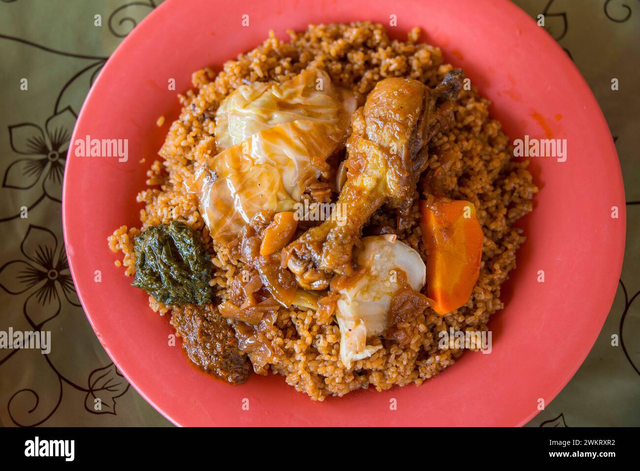 Piatto tipico di riso gambiano con pollo e verdure Foto Stock