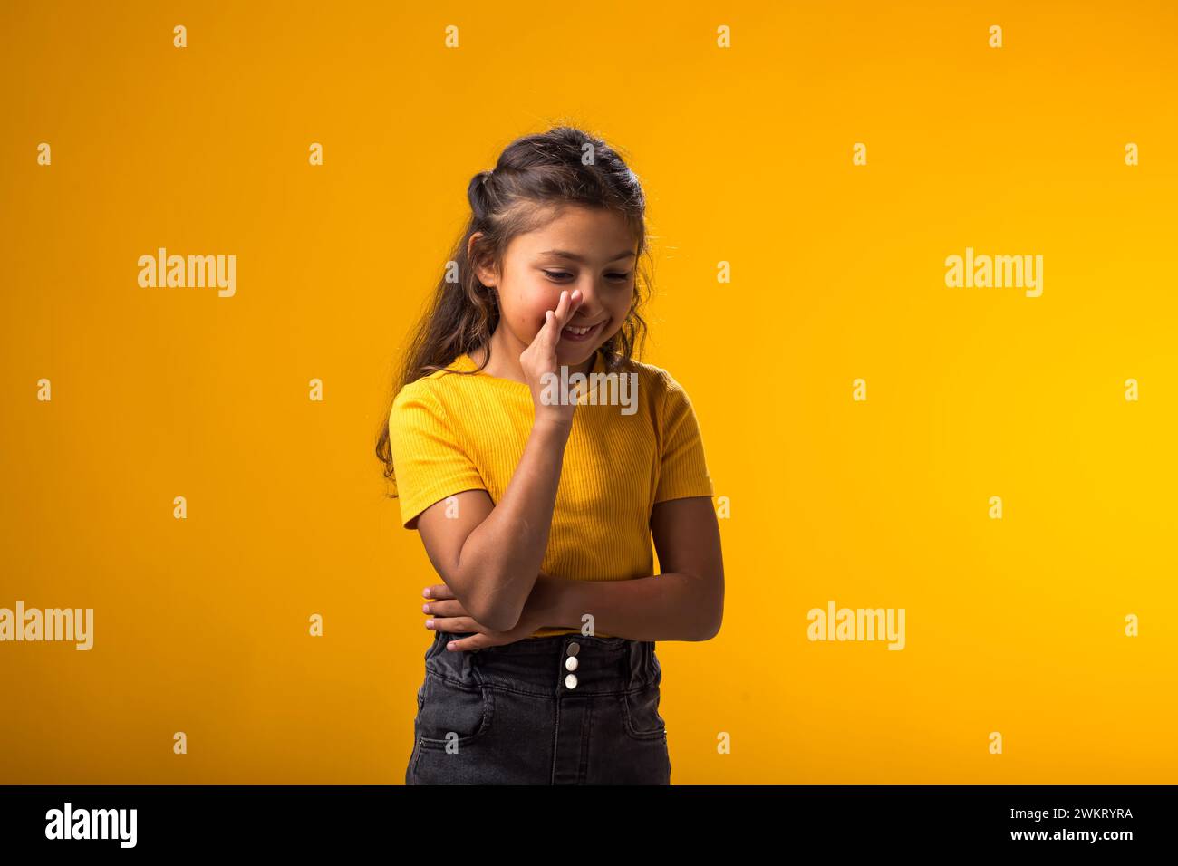 Ritratto di una bambina che urla e tiene il palmo vicino alla bocca aperta. Pettegolezzi e concetto segreto Foto Stock