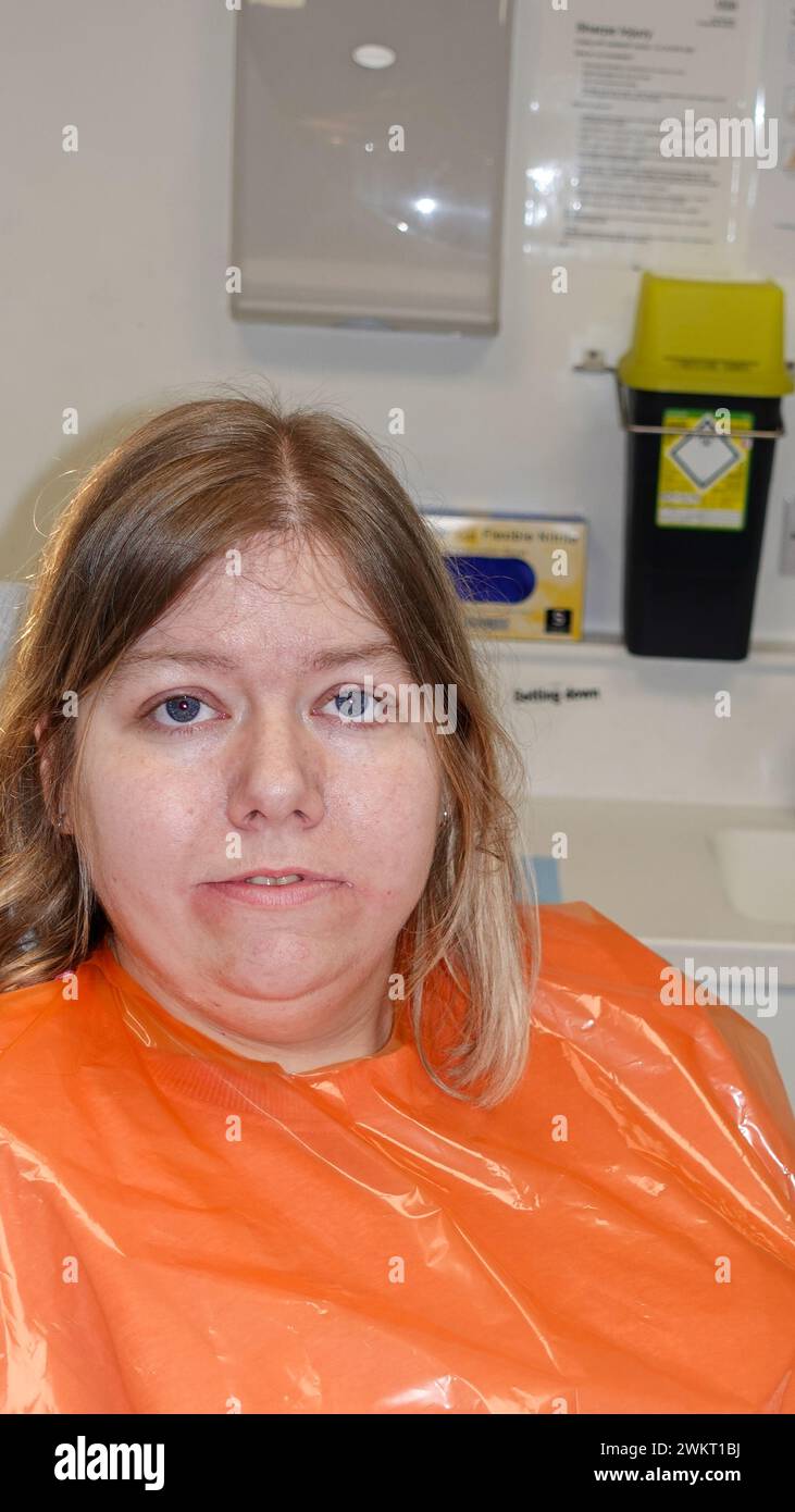 la paziente femminile nella sedia dentistica ha un'estrazione di due denti sagaci. Foto Stock