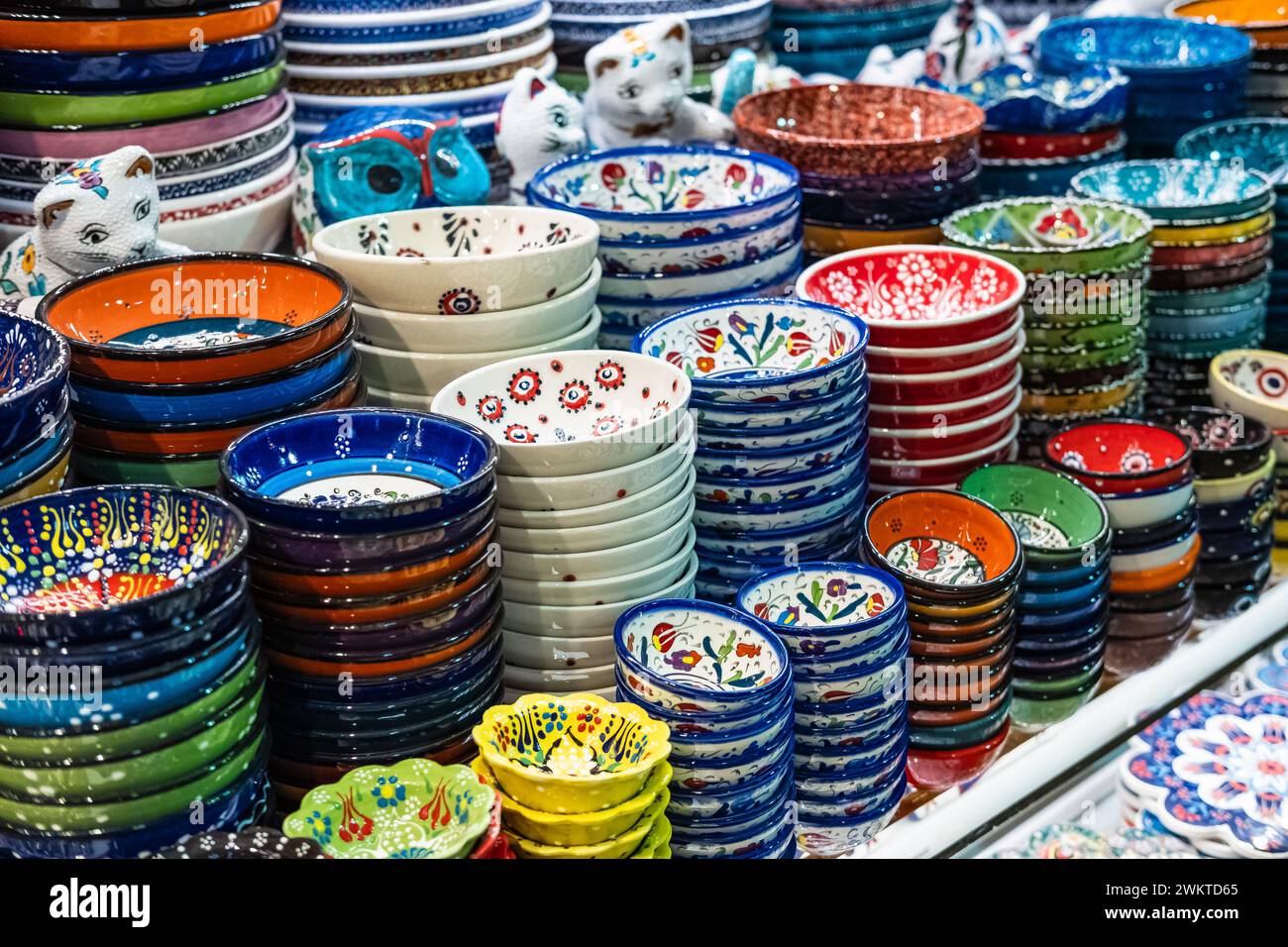 Varietà di piatti colorati verniciati a mano per la vendita in un mercato. Piastre decorative in ceramica su uno scaffale di un negozio. Collezione di ceramiche colorate Foto Stock