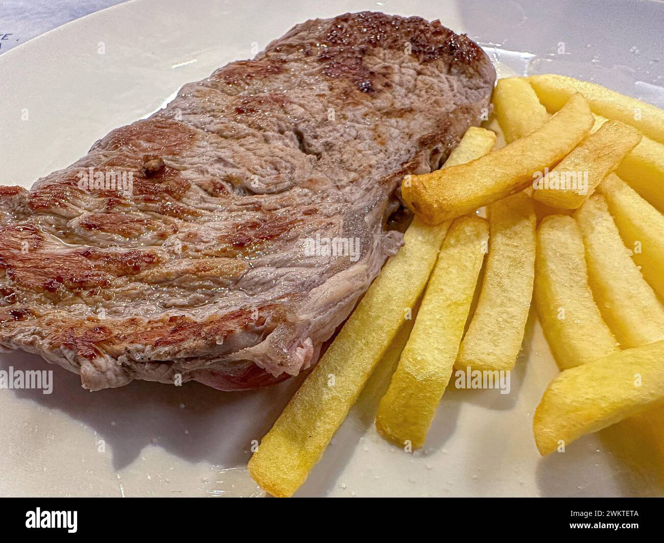 Bistecca di carne con patatine fritte nel ristorante, cucina vera ad Alicante, Spagna Foto Stock