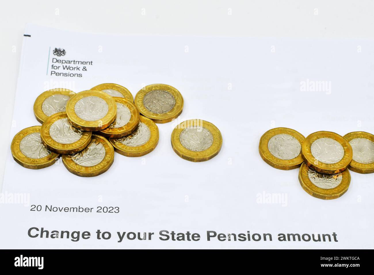 Cardiff, Galles - 1° gennaio 2024: Monete in sterline britanniche in aggiunta a una lettera del Dipartimento per il lavoro e le pensioni in merito a una modifica della pensione di Stato Foto Stock