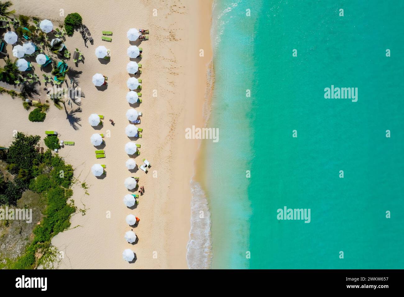Fotografia aerea che cattura la bellezza di Anguilla. L'immagine mostra ombrelloni colorati che punteggiano le sabbie bianche incontaminate, il turchese wat Foto Stock