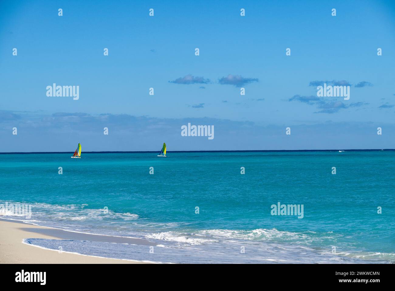 San Salvador Island Bahamas, catamarano che naviga sulle acque turchesi, cielo quasi nuvoloso, vele colorate, acque cristalline e calme, sport eccitanti, gioia Foto Stock