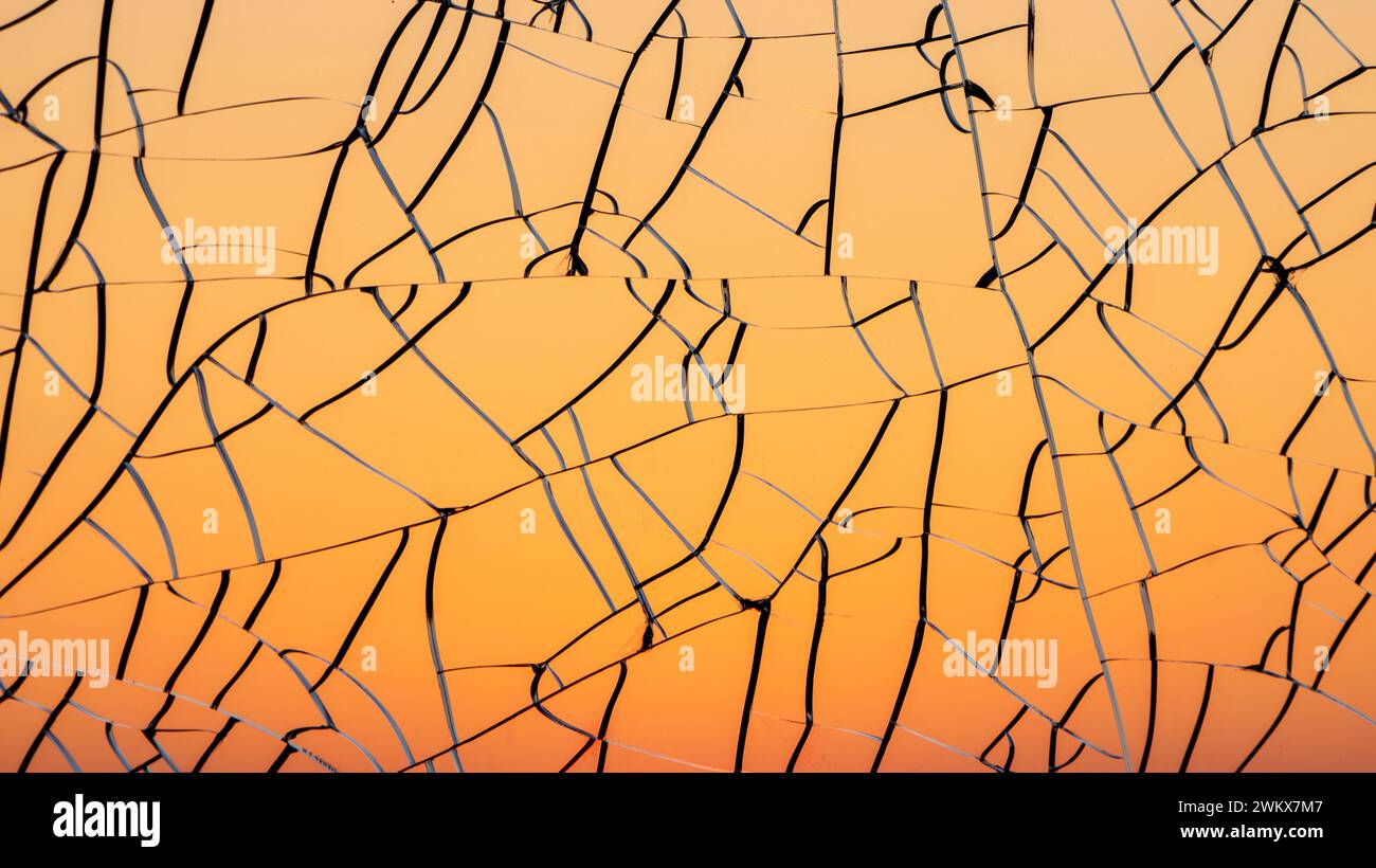 Sfumatura del tramonto attraverso il vetro incrinato Foto Stock