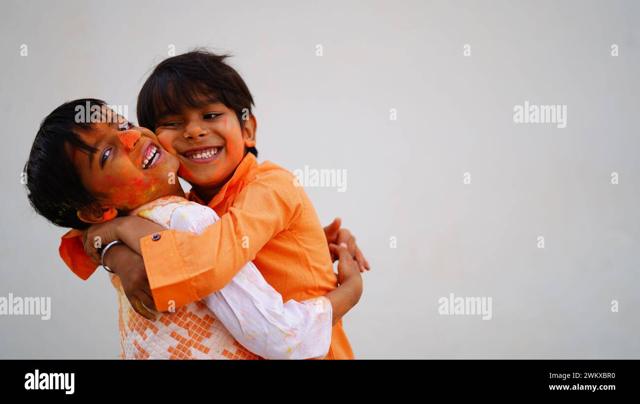 Bambini ricoperti di polvere colorata durante la festa di Holi. I bambini asiatici festeggiano il festival indiano holi con colorata polvere di vernice su fac Foto Stock