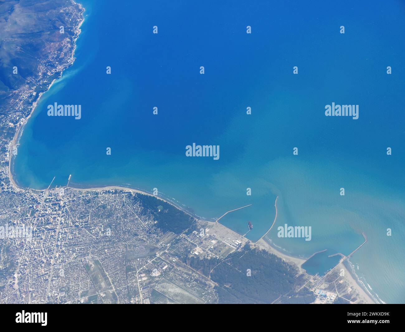 Sorvolando la città costiera sottostante, il paesaggio con porto nel blu blu del mediterraneo, vista aerea in aereo, destinazione di viaggio Foto Stock