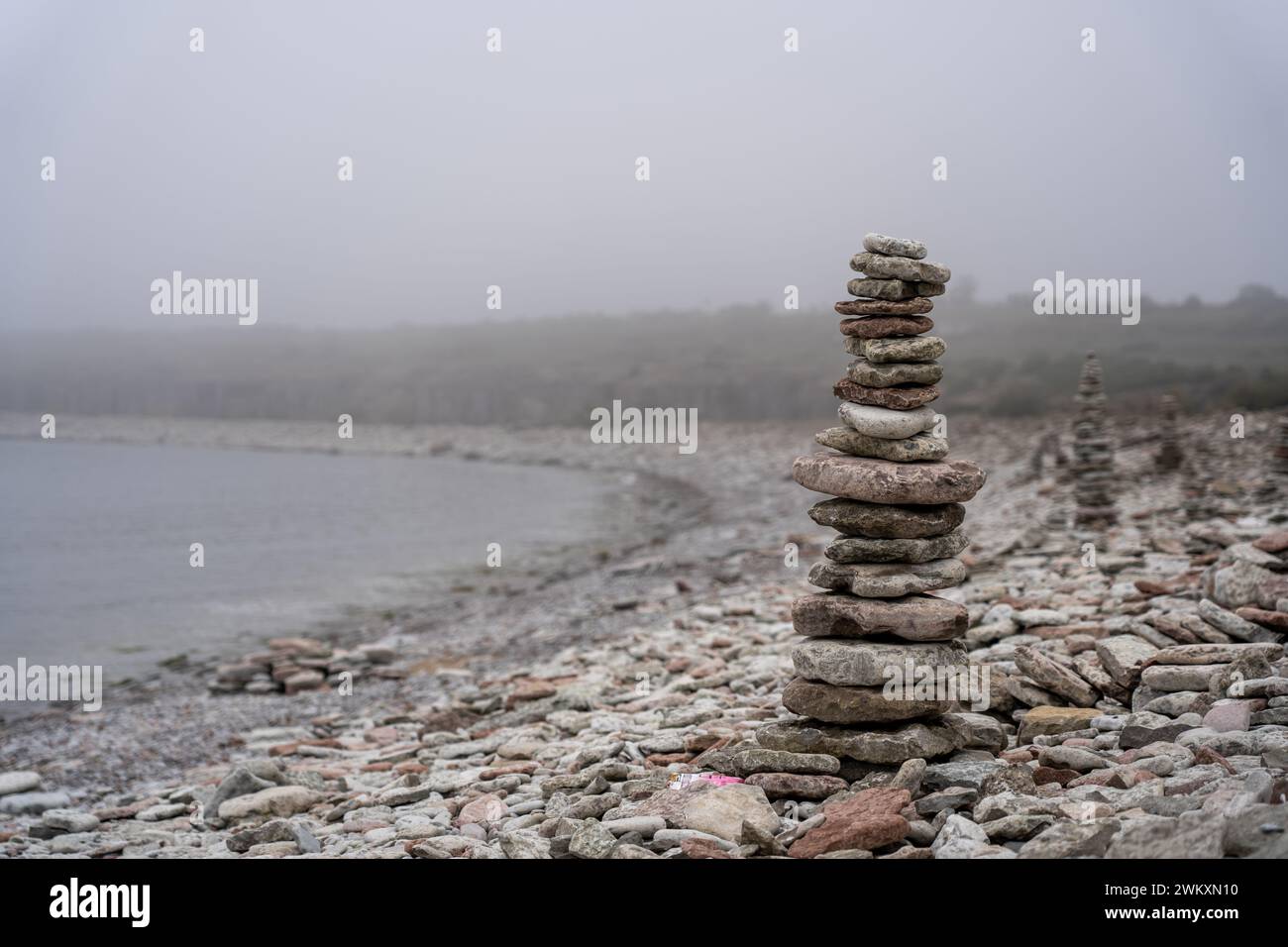 Una pila di rocce in cima a una salita rocciosa Foto Stock