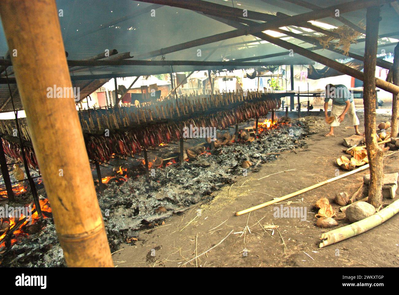 Un'industria domestica che produce tonno striato affumicato a Bitung, Sulawesi settentrionale, Indonesia. I contributi delle conoscenze indigene all'innovazione tecnologica offrono un'ampia gamma di opzioni per la gestione, tra l'altro, della sicurezza alimentare, secondo la relazione 2023 del gruppo intergovernativo di esperti sui cambiamenti climatici (IPCC). Popolarmente conosciuto come cakalang fufu, il tonno affumicato è considerato un alimento indigeno esotico e potrebbe diventare una soluzione alternativa per affrontare gli impatti del cambiamento climatico sull'oceano. Foto Stock