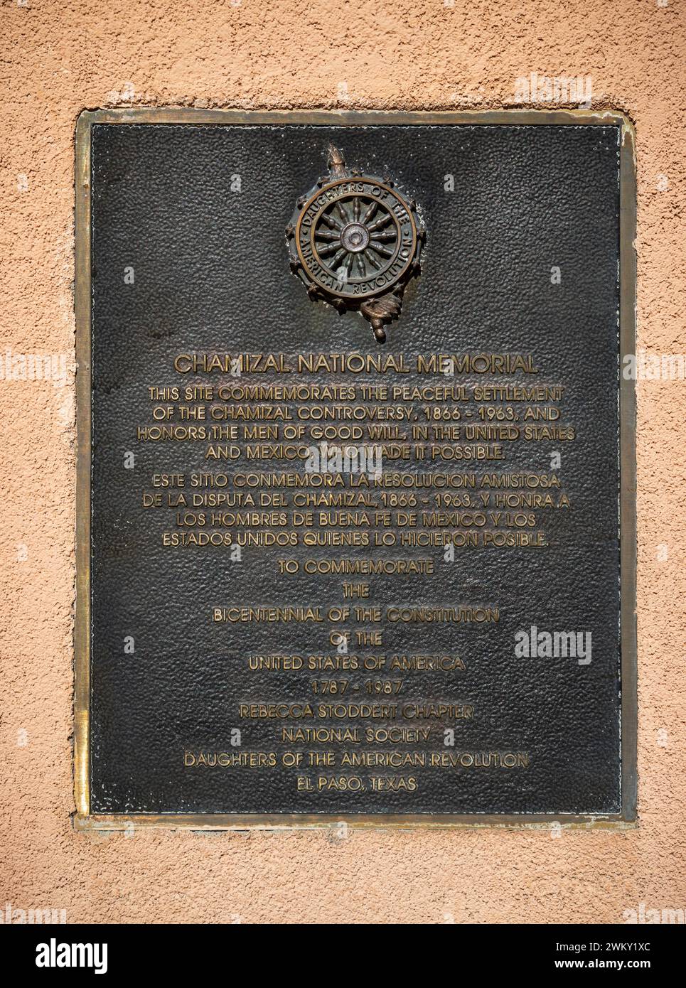 Una targa di bronzo intitolata Chamizal National Memorial, con testo in inglese e spagnolo, è montata su un muro di stucco rosa a El Paso, Texas. Foto Stock