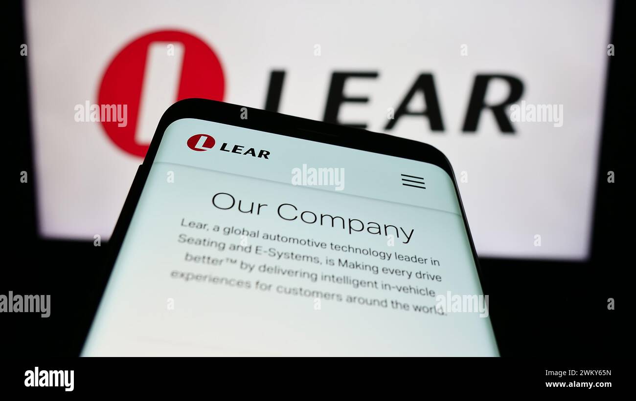 Smartphone con pagina Web della società di fornitura automobilistica statunitense Lear Corporation davanti al logo aziendale. Mettere a fuoco in alto a sinistra sul display del telefono. Foto Stock