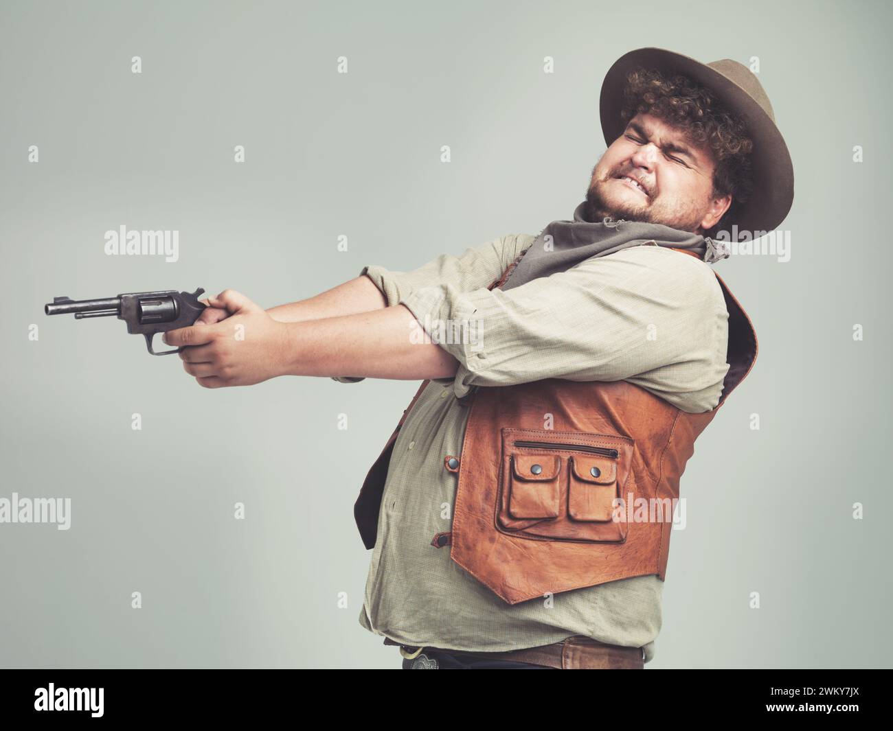 Cowboy, uomo divertente e pistola da tiro in studio, arma e pistola per combattimento western isolati su uno sfondo bianco. Più dimensione, criminale e persona con Foto Stock