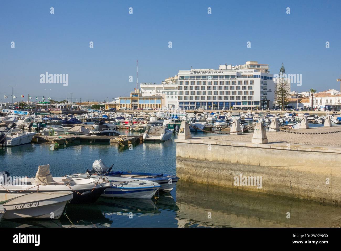 Barche ormeggiate a Faro Portugal Marina, l'Eva Senses Hotel sullo sfondo Faro è il centro amministrativo dell'Algarve, sede dell'aeroporto Foto Stock