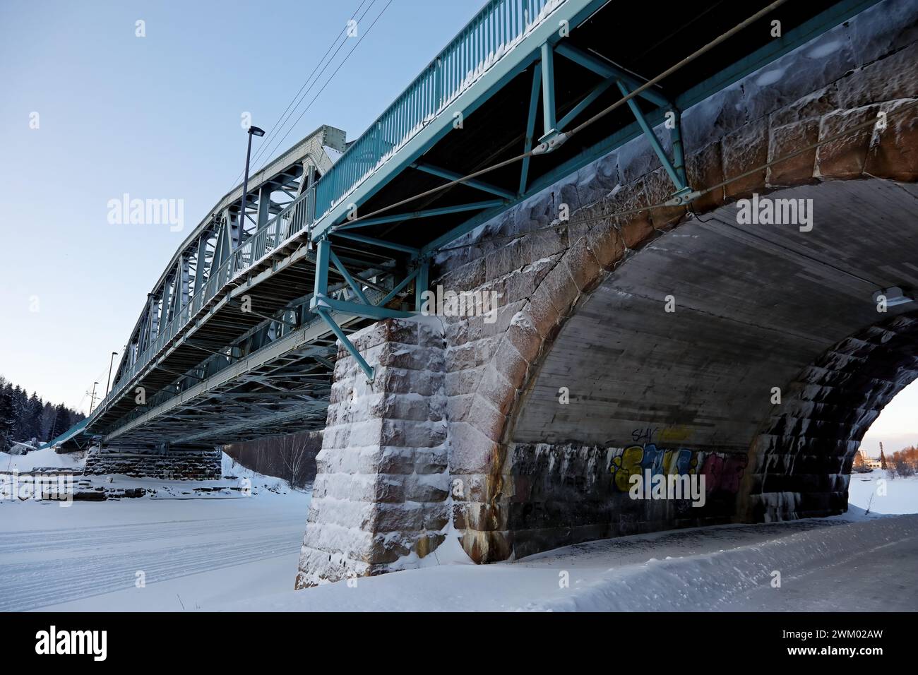 Ponte ferroviario e sassone in corso d'inverno Foto Stock