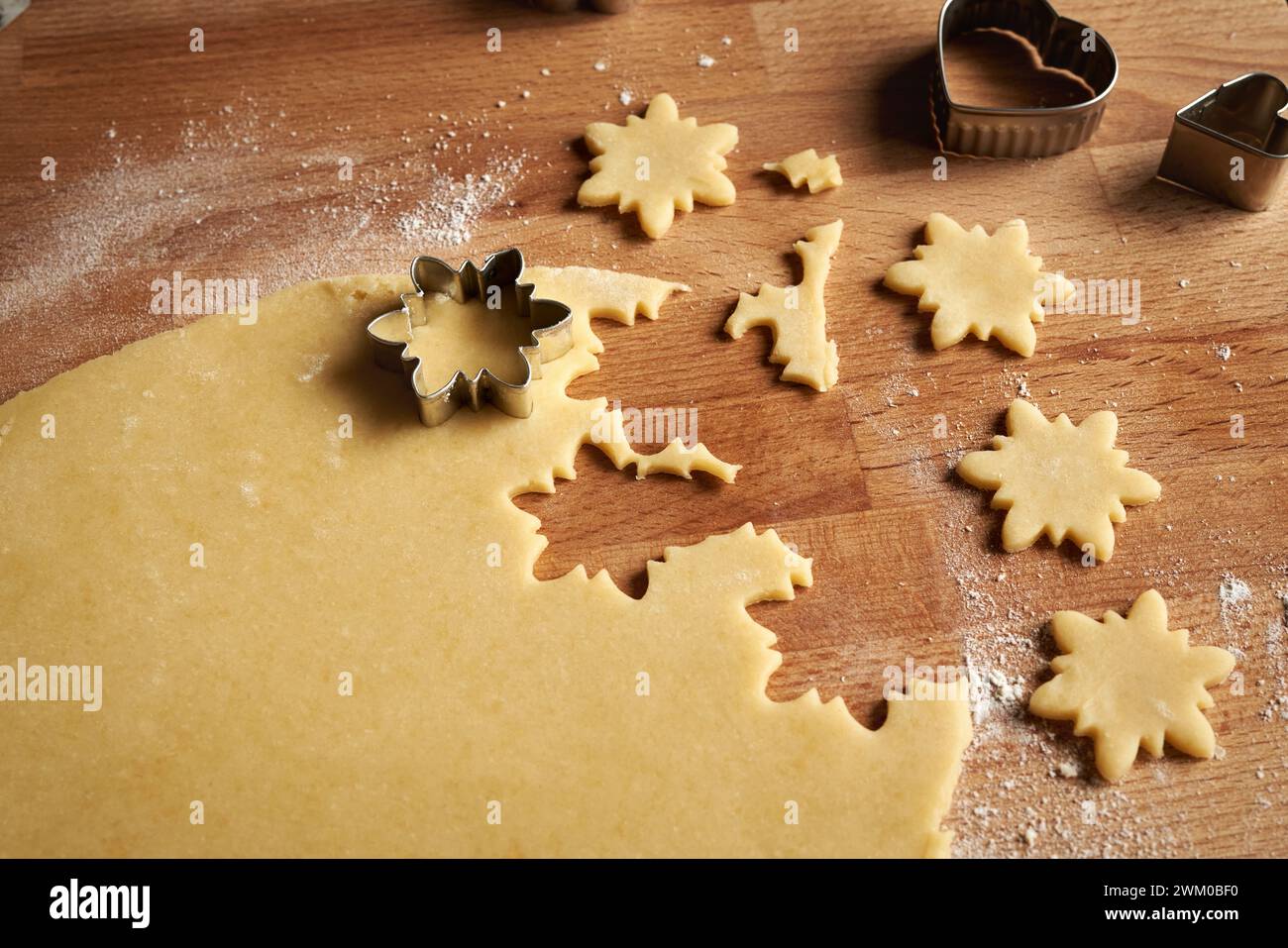 Il taglio di forme stellari da pasta laminata per preparare Linzer biscotti di Natale Foto Stock