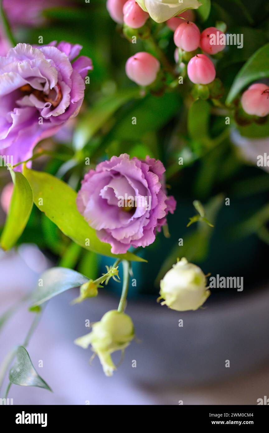 Fiori viola in vaso verde con tessuto bianco e filo d'argento Foto Stock